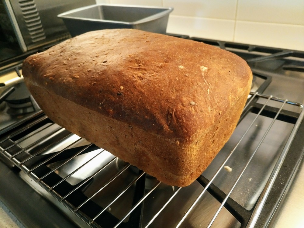 Golden baked loaf, cooling on a cooling rack